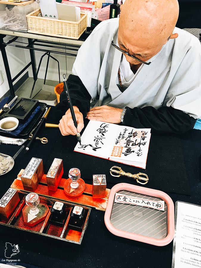 Moine en train de faire un goshuin lors de mon voyage au Japon en train dans notre article Visiter le Japon : Mes trucs et astuces pour un voyage au Japon réussi #japon #asie #voyage #goshuin #temple