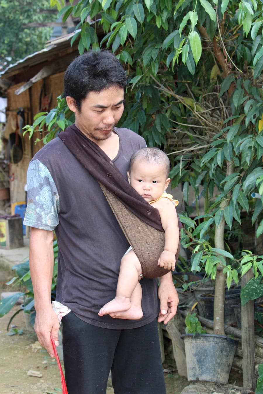Hommes s'occupent des enfants dans les tribus du nord de la Thaïlande dans notre article Road trip au nord de la Thaïlande à la rencontre des tribus des montagnes #thailande #nord #tribu #peuple #montagnes #roadtrip #asie #voyage