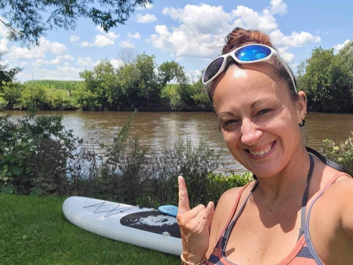 L'autrice qui se prépare à partir en paddleboard dans dans notre article Les meilleurs endroits pour faire du paddleboard au Québec #paddleboardquebec #supquebec #plancheapagaiequebec