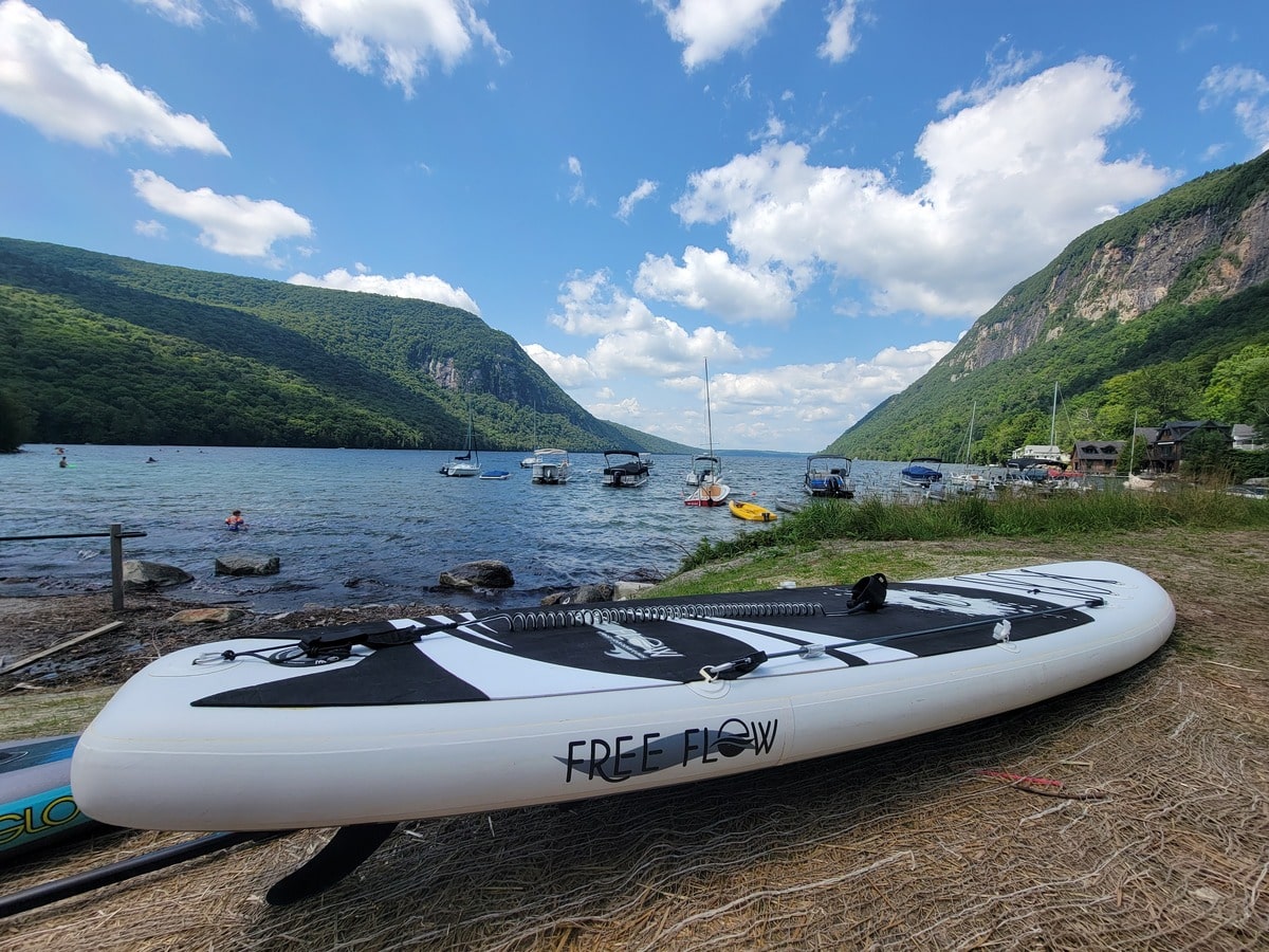Paddleboard devant la plage et les montagnes au Lake Willoughby au Vermont dans notre article Les meilleurs endroits pour faire du paddleboard au Québec #paddleboardquebec #supquebec #plancheapagaiequebec
