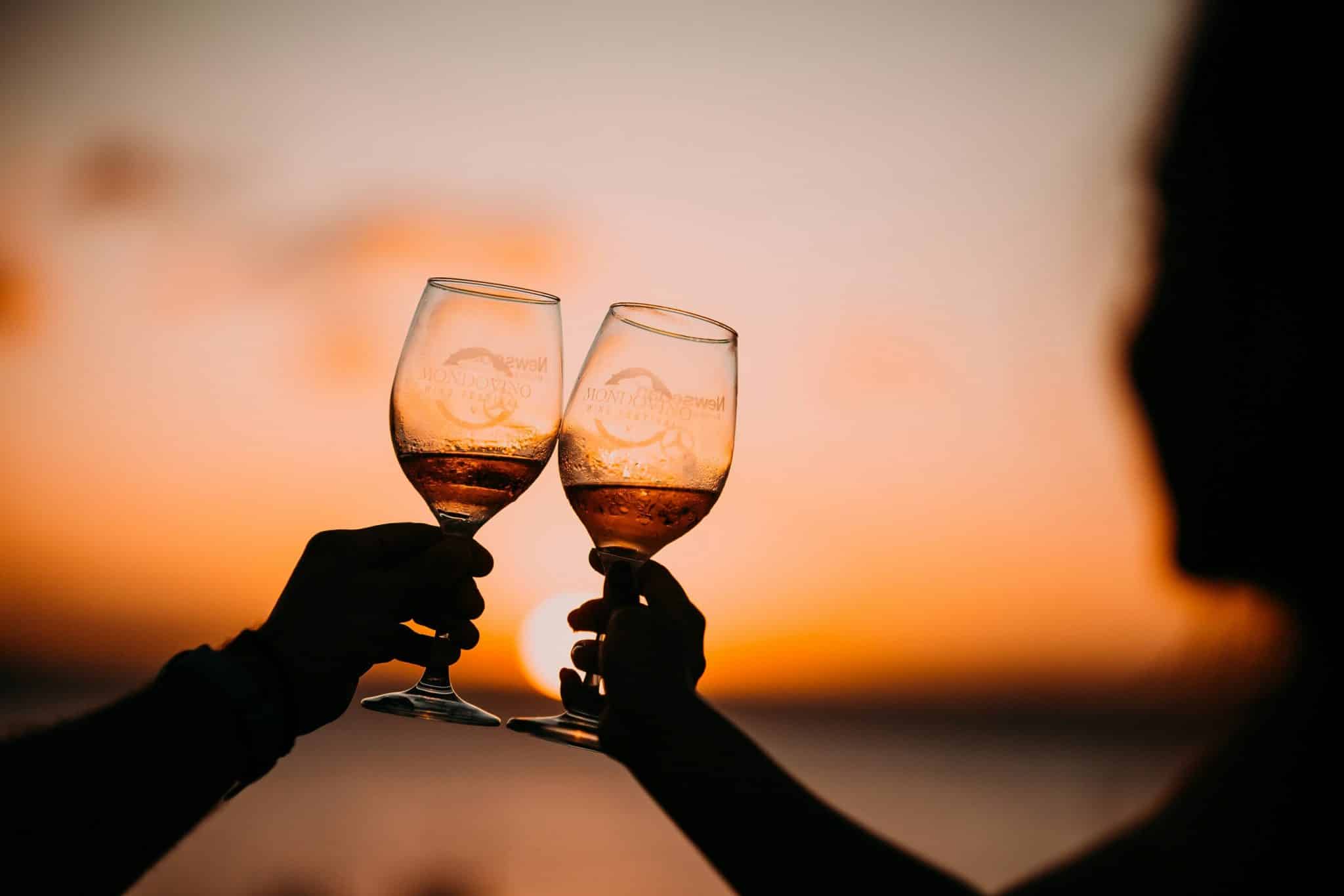 Couple qui font un cheers ensemble avec leur coupes de vin dans notre article Où voyager en amoureux : 5 destinations pour des vacances en amoureux réussies #quebec #europe #sardaigne #grenade #charlevoix #cantonsdelest