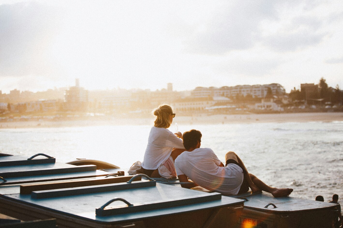 couple assis ensemble sur un quai qui regardent vers le large dans notre article Où voyager en amoureux : 5 destinations pour des vacances en amoureux réussies #quebec #europe #sardaigne #grenade #charlevoix #cantonsdelest
