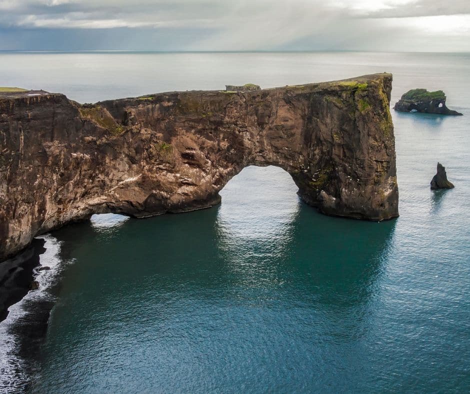 Grand trou dans une falaise au milieu de la mer dans notre article 5 jours en Islande : Road trip en dehors des itinéraires classiques #islande #roadtrip #europe
