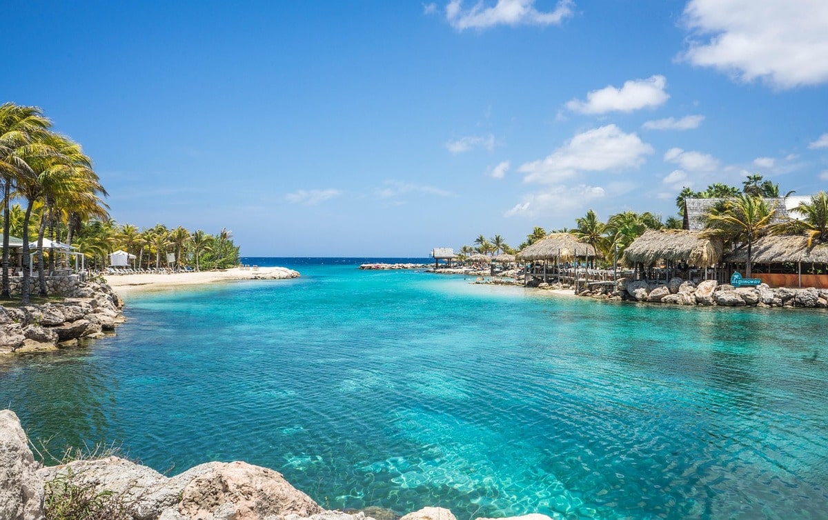 Baie turquoise avec villages et palmiers autour en voyage organisé sur l'île de Curaçao entre femmes #curacao #antilles #caraibes #voyageentrefemmes #voyage #voyagedegroupe #voyageorganise