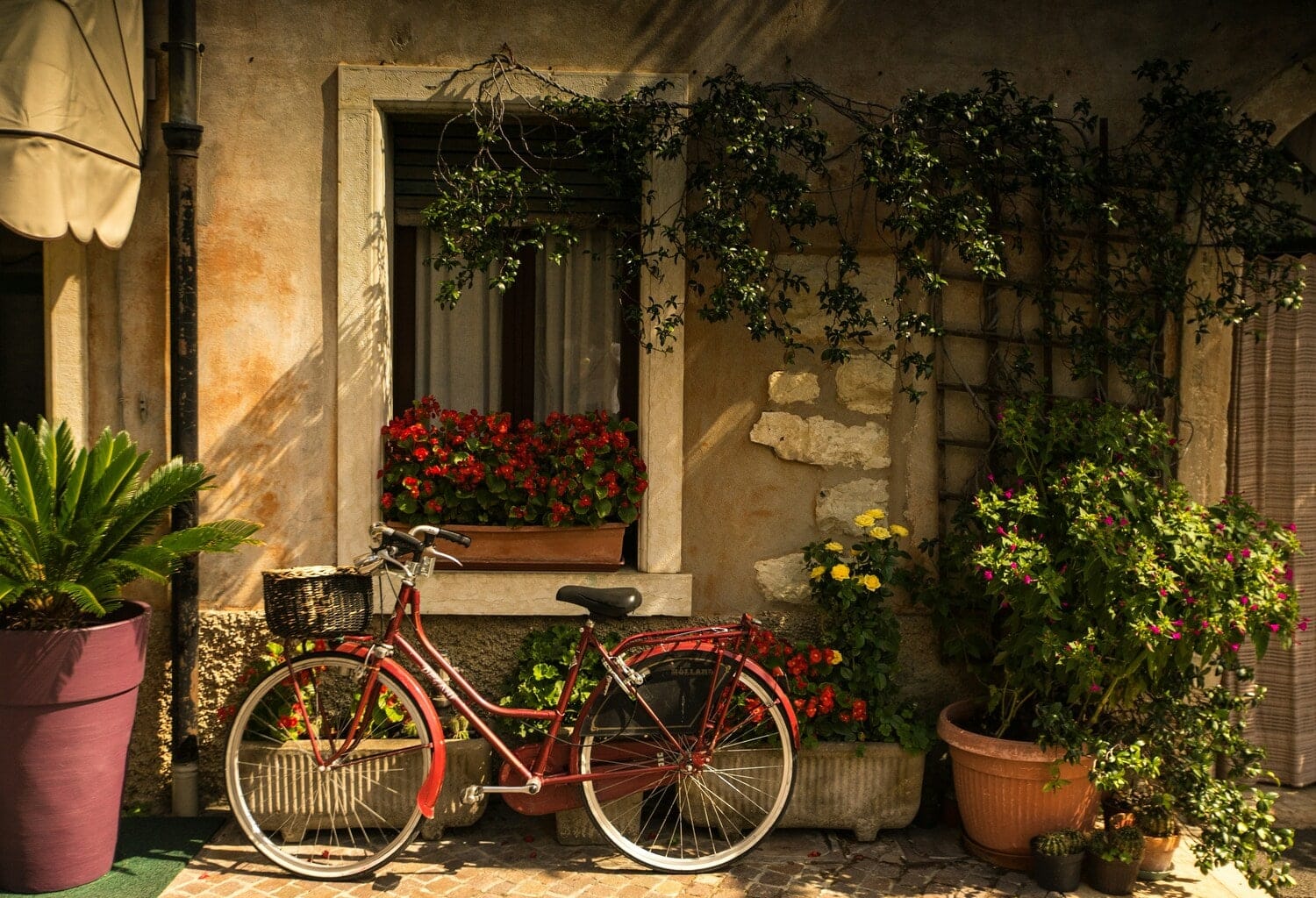 Vélo rouge près d'une maison en fleur dans notre article 5 beaux endroits où faire du vélo au Québec #quebec #velo #pistecyclable