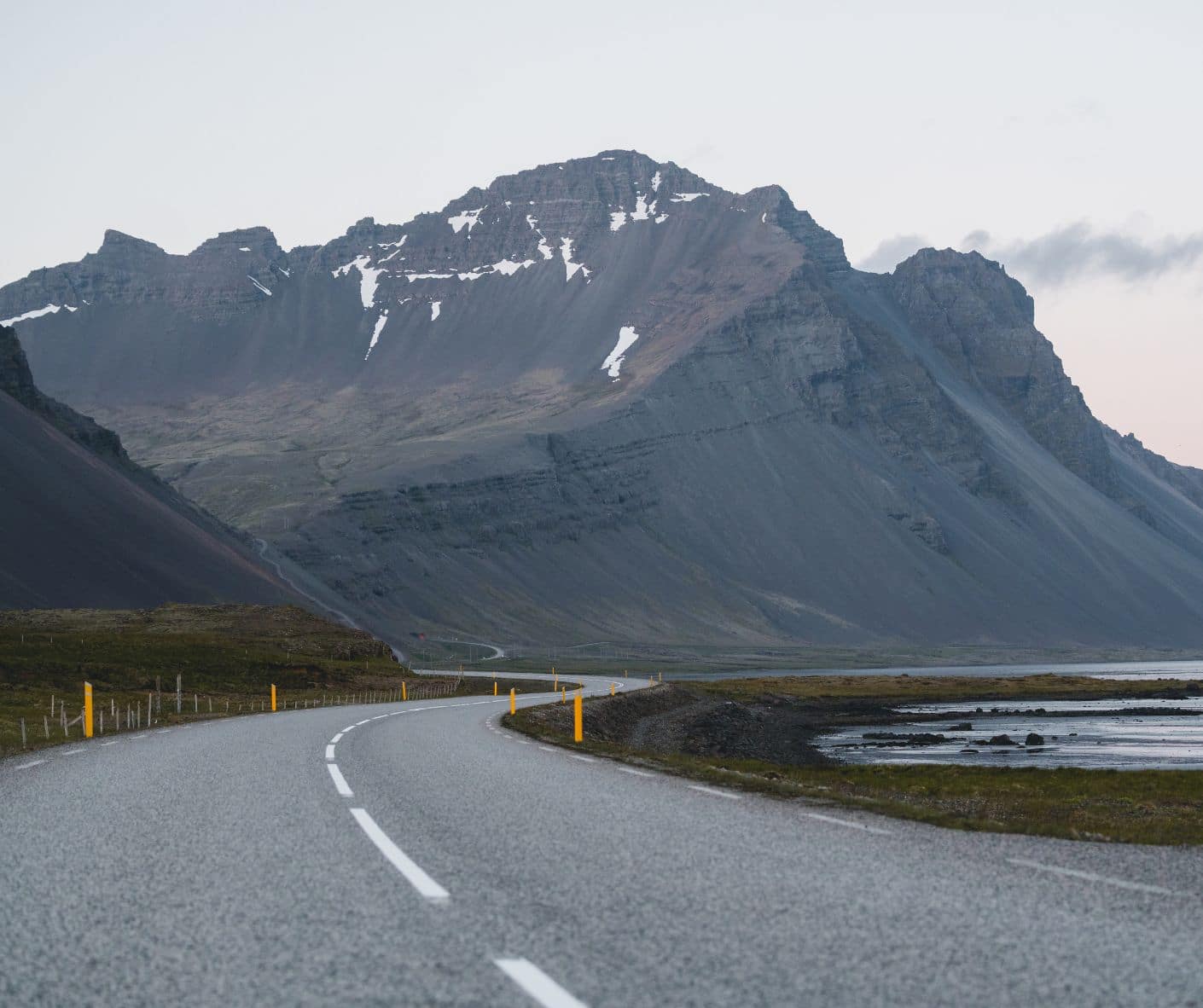 Route asphaltée vers les montagnes enneigées dans notre article Comment louer une voiture en Islande sans stress : 5 erreurs à éviter #islande #roadtrip #europe #locationvoiture