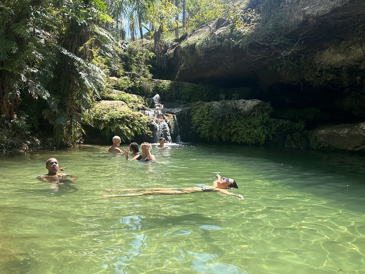 Gens qui se baignent dans la piscine naturelle de l'oasis du parc national Isalo dans notre Voyage à Madagascar organisé en petit groupe de femmes #Madagascar #voyageentrefemmes #voyage #voyagedegroupe #voyageorganise