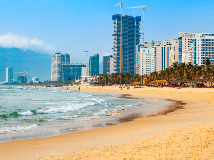 plage de Danang avec les grandes tours commerciales derrière, dans notre voyage organisé entre femmes au Vietnam grand circuit du nord au sud #Vietnam #nordausud #voyageentrefemmes #voyage #voyagedegroupe #voyageorganise